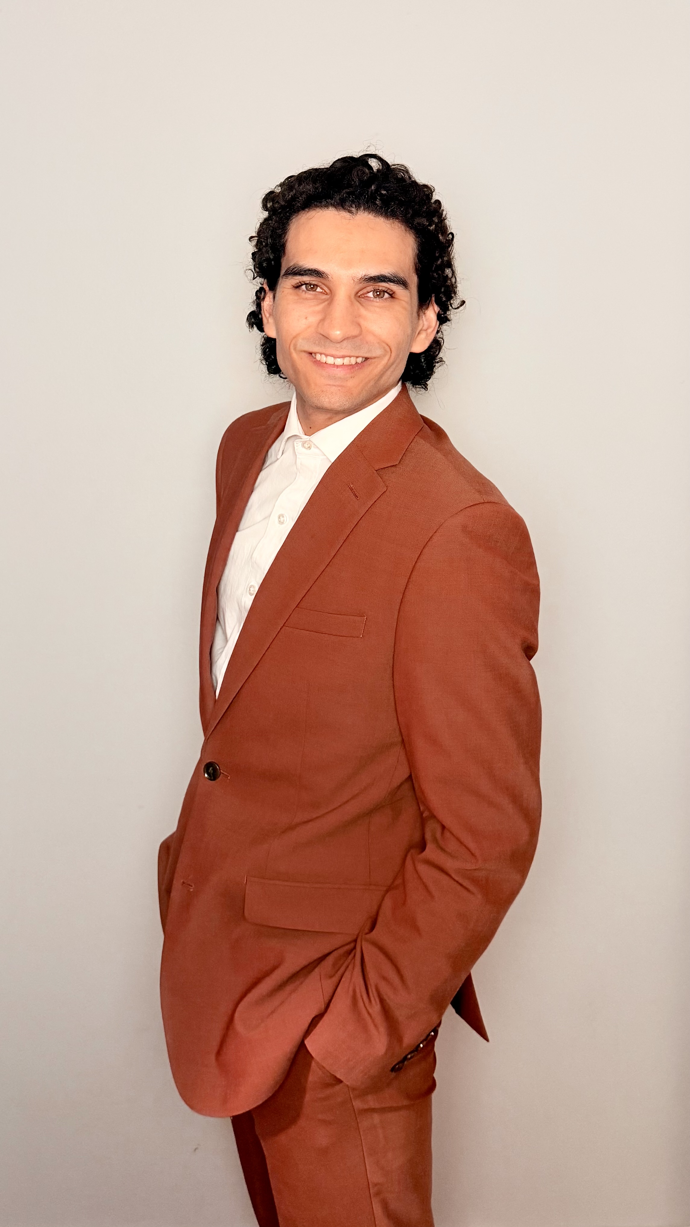 PJ Santos · Founder & Principal Architect, CysecIn LLC — wearing a rust-orange suit on the SOF Week 2026 floor